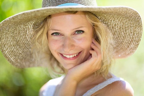 Smiling young woman with summer hat