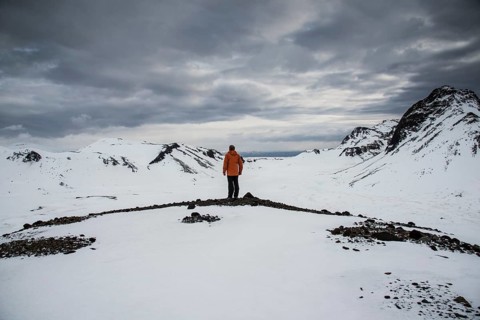 Man looking from a lookout point over a snow-covered landscape
