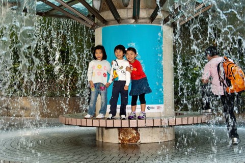 Children standing on a fountain