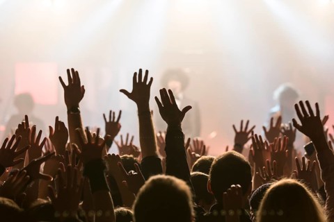 Concertgoers stretching their hands in the air at the concert of the Swiss pop band Pegasus