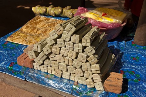 Palm sugar packed in palm leaves for sale at a market stall