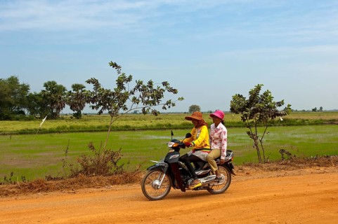 Two women riding on a motorcycle on a country road