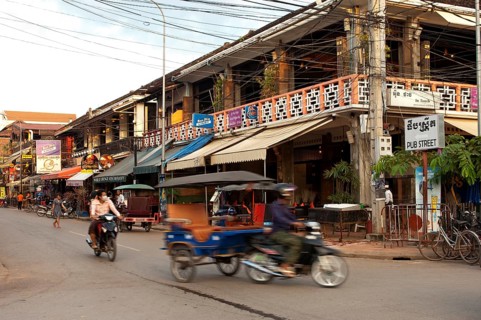 Rickshaw in traffic in front of restaurants and bars in Pub Street