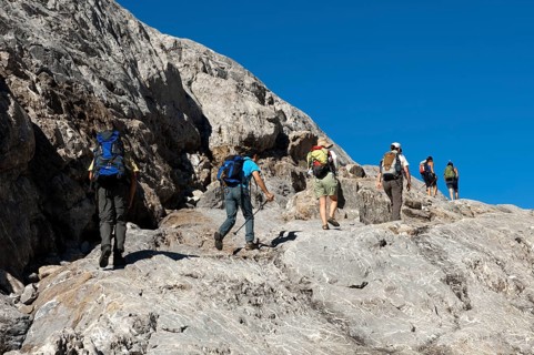 Hikers crossing the exposed bedrock of Tsanfleuron Glacier