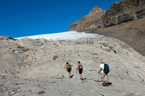 Hikers crossing the exposed bedrock of Tsanfleuron Glacier