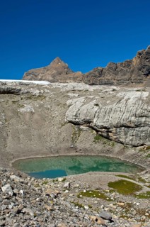 Lake of green meltwater in a doline or sinkhole in the end moraine of Tsanfleuron Glacier at Sanetsch Pass