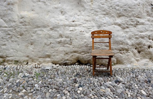Old folding chair in front of a wall