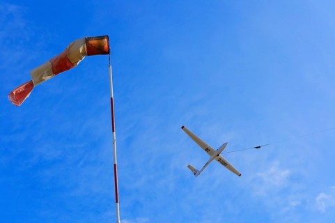 Windsock and a glider during a winch launch against the wind