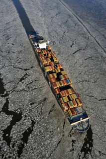 Container ship on the Elbe River with ice flow