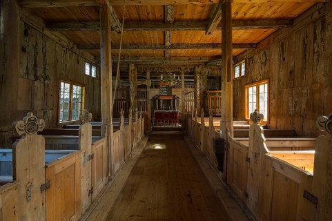 Stave church interior with pews and an altar
