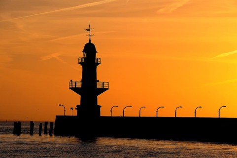 Silhouette of the Brunsbuttel Mole 1 lighthouse in front of a evening sky
