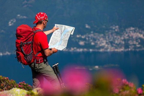 Man studying the trail map while hiking on Monte Covreto