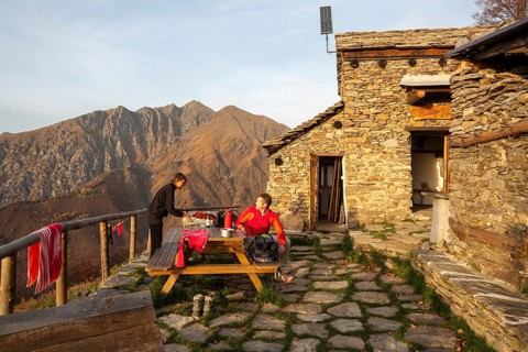 Two hikers at the Bivacco Alpe Curgei mountain hut