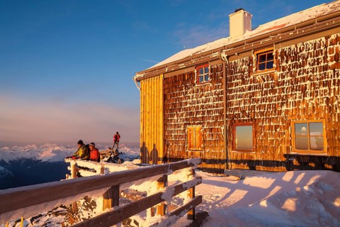 Two mountaineers watching the sunrise at the Archduke Johann cabin on Mt Grossglockner