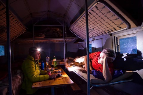 A man and a woman inside the Bivacco del Baus refuge