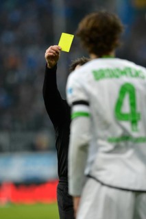 Referee Peter SIPPEL showing a yellow card to Roel BROUWERS of Borussia Moenchengladbach for committing a foul