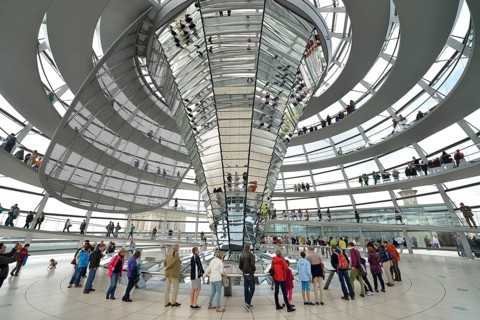 Visitors in the interior with the mirrored central column of the dome of the Reichstag Building