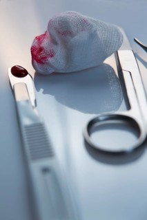 Scalpel and blood on a cotton swab
