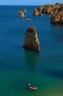 Boat off the cliffs at Praia da Dona Ana beach