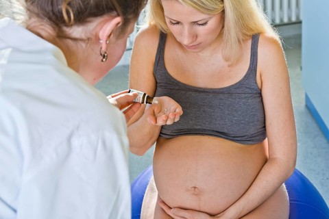 Pregnant woman recieving homeopathic medicine from her midwife during delivery
