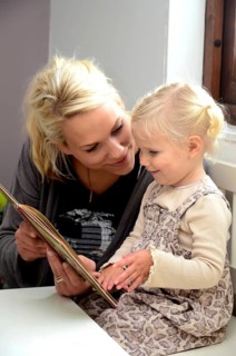 Mother reading a book with her little daughter
