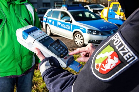 Police officer collecting an on-the-spot fine with a card reader