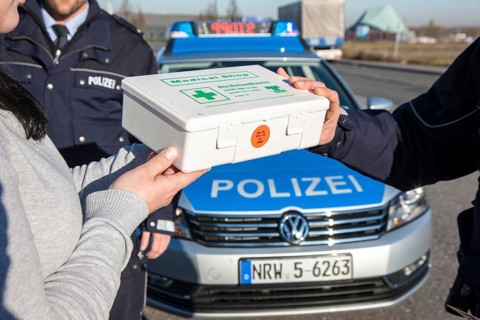 Policeman checking a first aid box during a traffic control