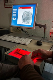 Fingerprints and palm prints of a suspicious person are recorded with a scanner