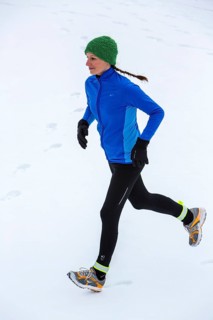 Female jogger on a run in winter in the snow