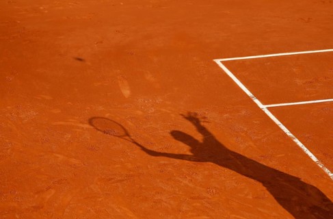 Shadow of a tennis player serving the ball