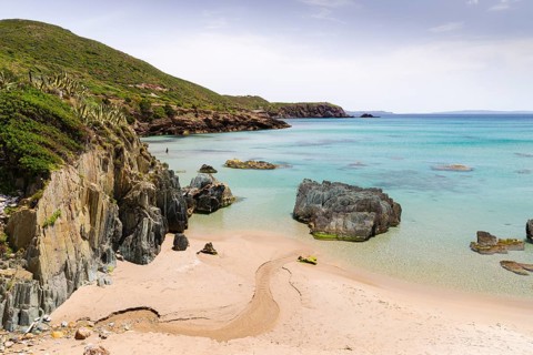 A creek running through the sand of the Spiaggia di Planusartu bay into the sea