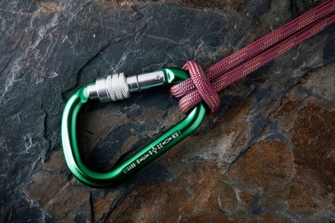 Carabiner with rope on a stone surface
