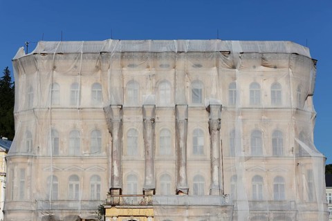 Facade of a historic building shrouded with tarpaulins during renovation