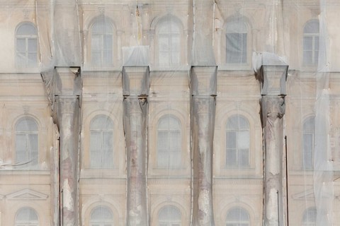 Facade of a historic building shrouded with tarpaulins during renovation