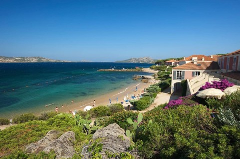 Beach of Porto Faro with the lighthouse at Capo d'Orso