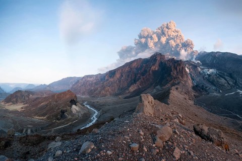 Ash cloud from Eyjafjallajoekull volcano above a glacier and Porsmoerk valley