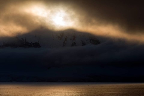 Low-standing sun shining through dense cloud cover