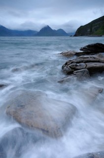 Mountains shrouded with clouds on a rocky seashore
