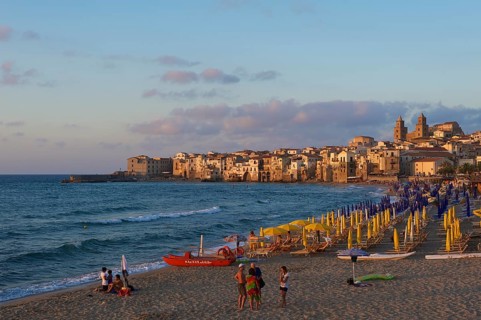 Beach and historic town centre with Cathedral of San Salvatore at dusk