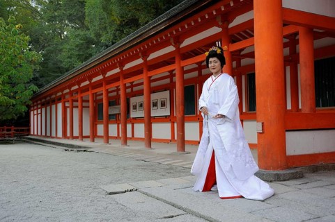 Bride in a traditional kimono with brocade holding a fan