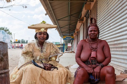 Herero woman and Himba woman woman in traditional dress sitting next to each other