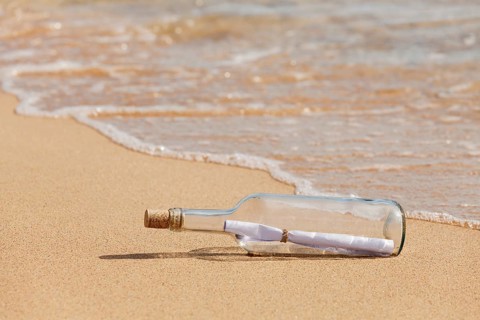 Message in a bottle lying on the beach