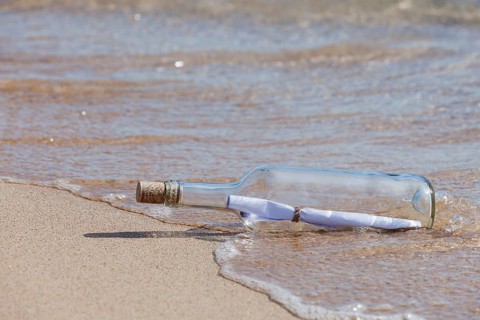 Message in a bottle lying on the beach