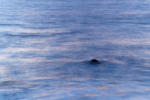Rock poking out of the sea in the evening