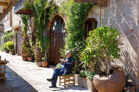 Man sitting on a chair in front of a hotel