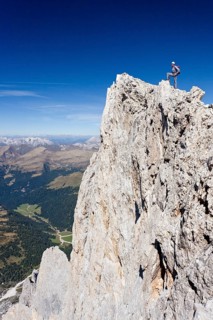 Climber on the summit of Cima Vezzena Mountain in the Pala Group
