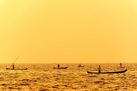 Fishermen in their boats at sunrise