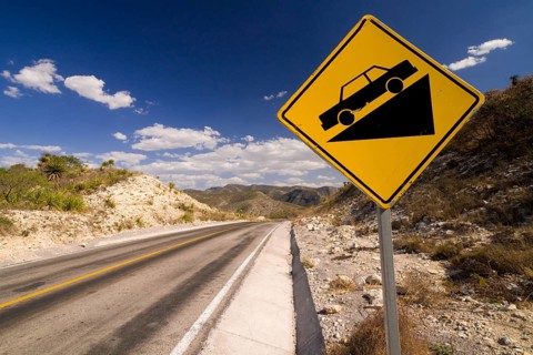 Warning sign on a sloping road