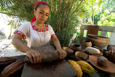 Farm worker grinding cocoa beans at the Hacianda Cacaotera 'Jesus Maria'