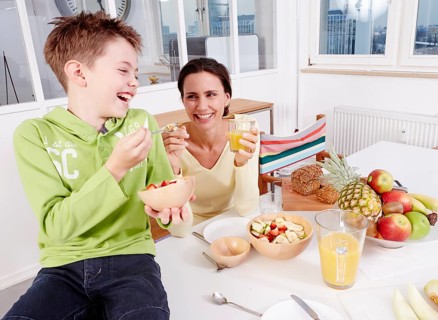 Mother and son eating fresh fruit and granola